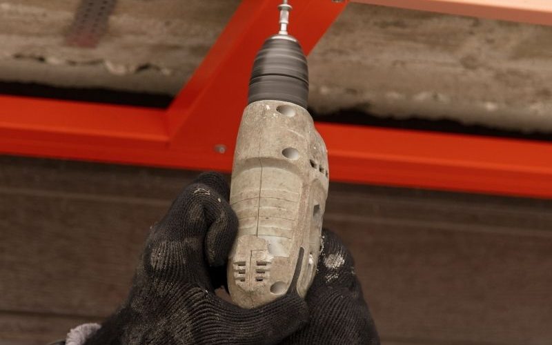 someone using a drill to install a garage door